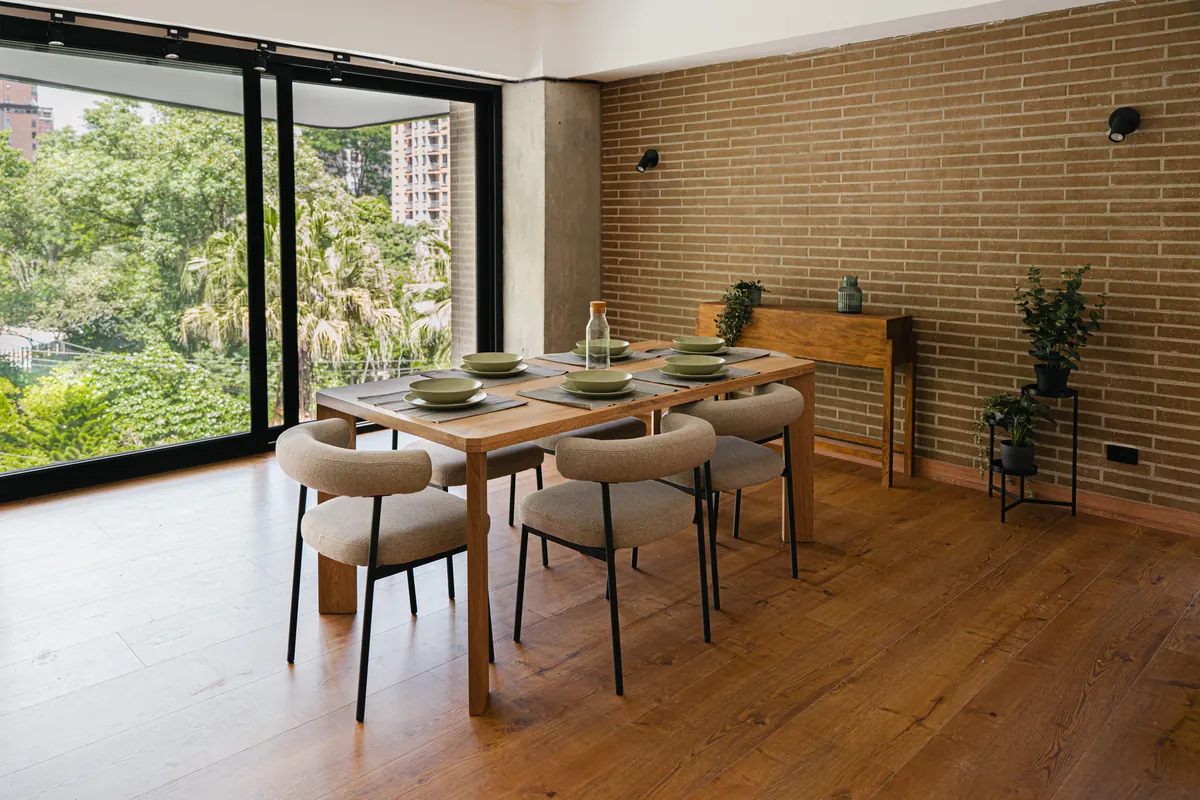 Comedor junto al ventanal con vista al follaje del barrio