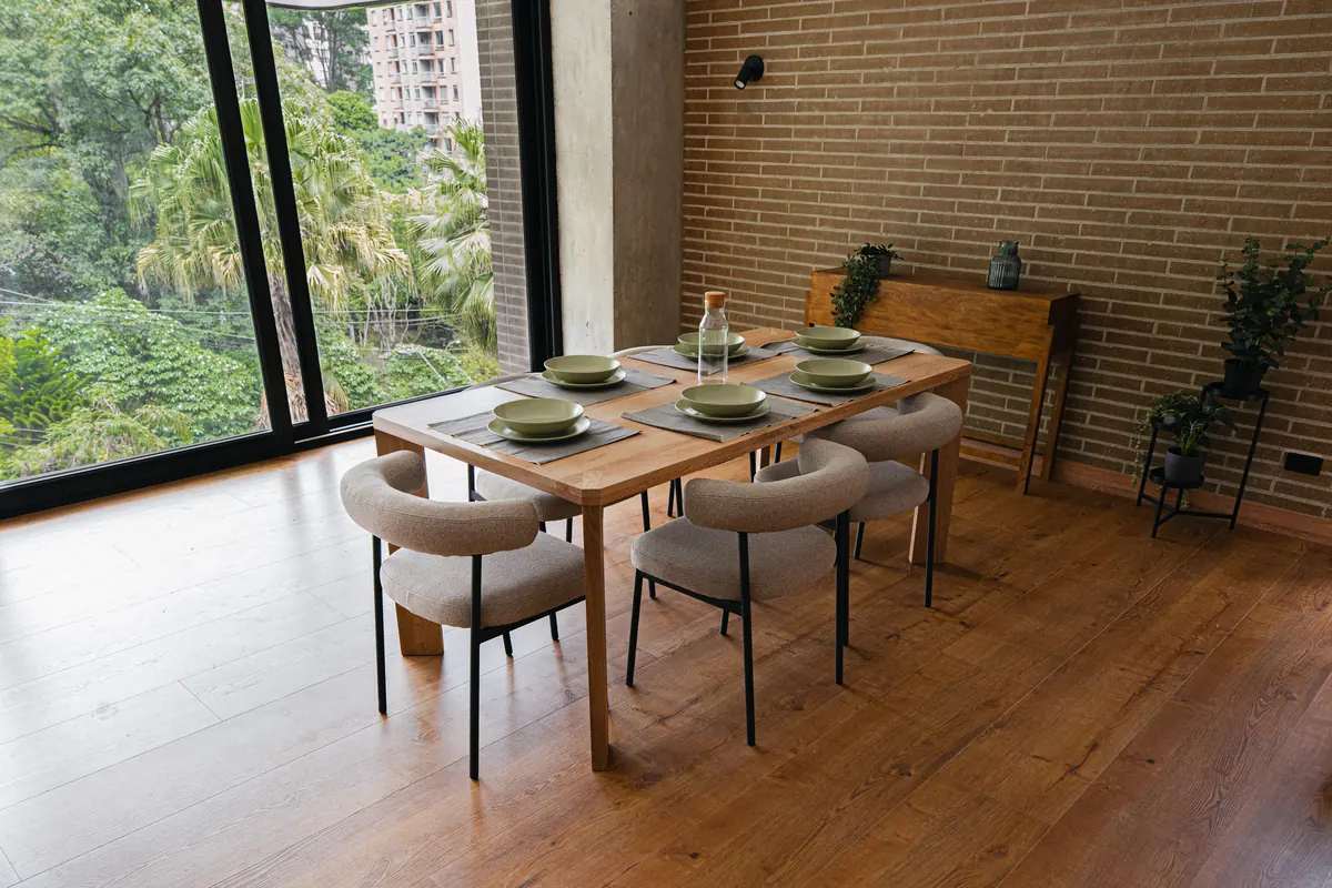 Comedor junto al ventanal con vista al follaje
