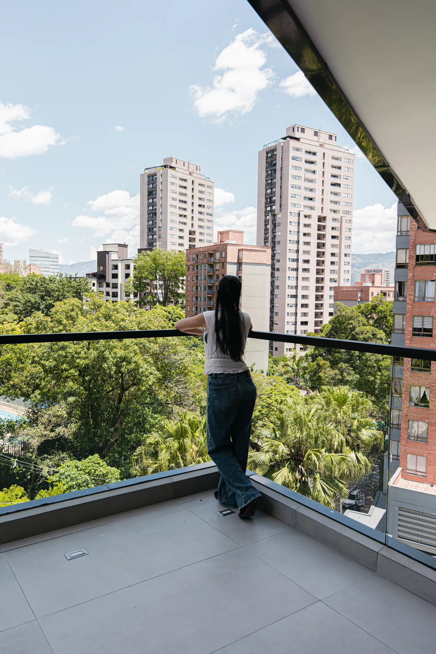 Terraza de Altitud con vista a las copas de los árboles y los edificios de Castropol, Medellín